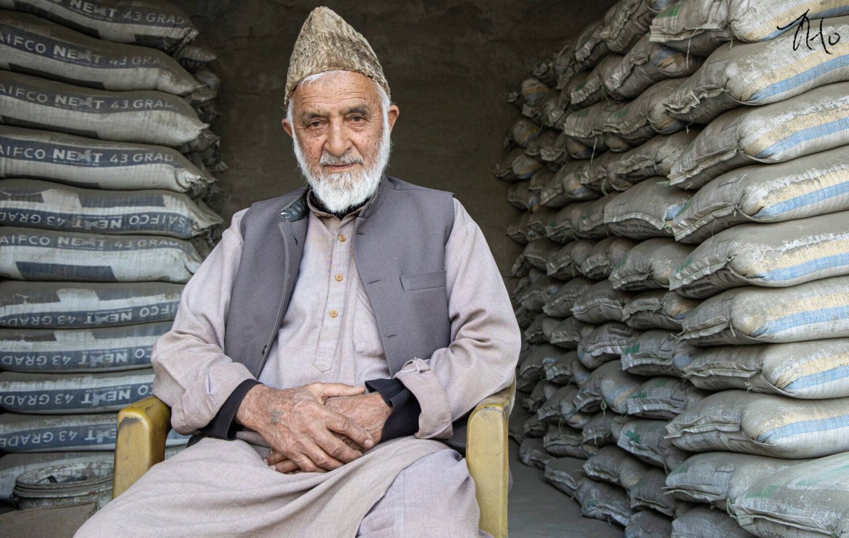 A man sitting in front of sacks of flour.