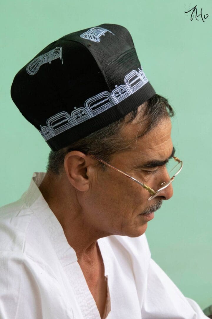 A man wearing a black hat and glasses.