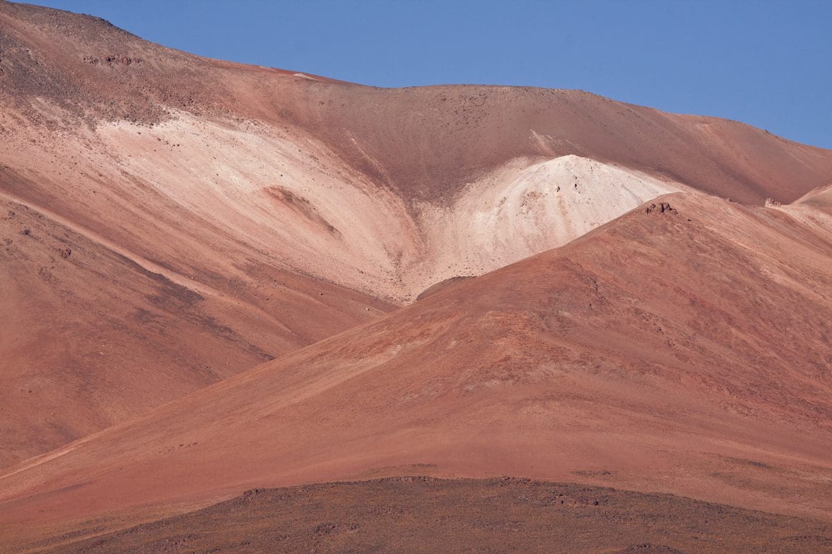 An image of a mountain with red and white paint on it.