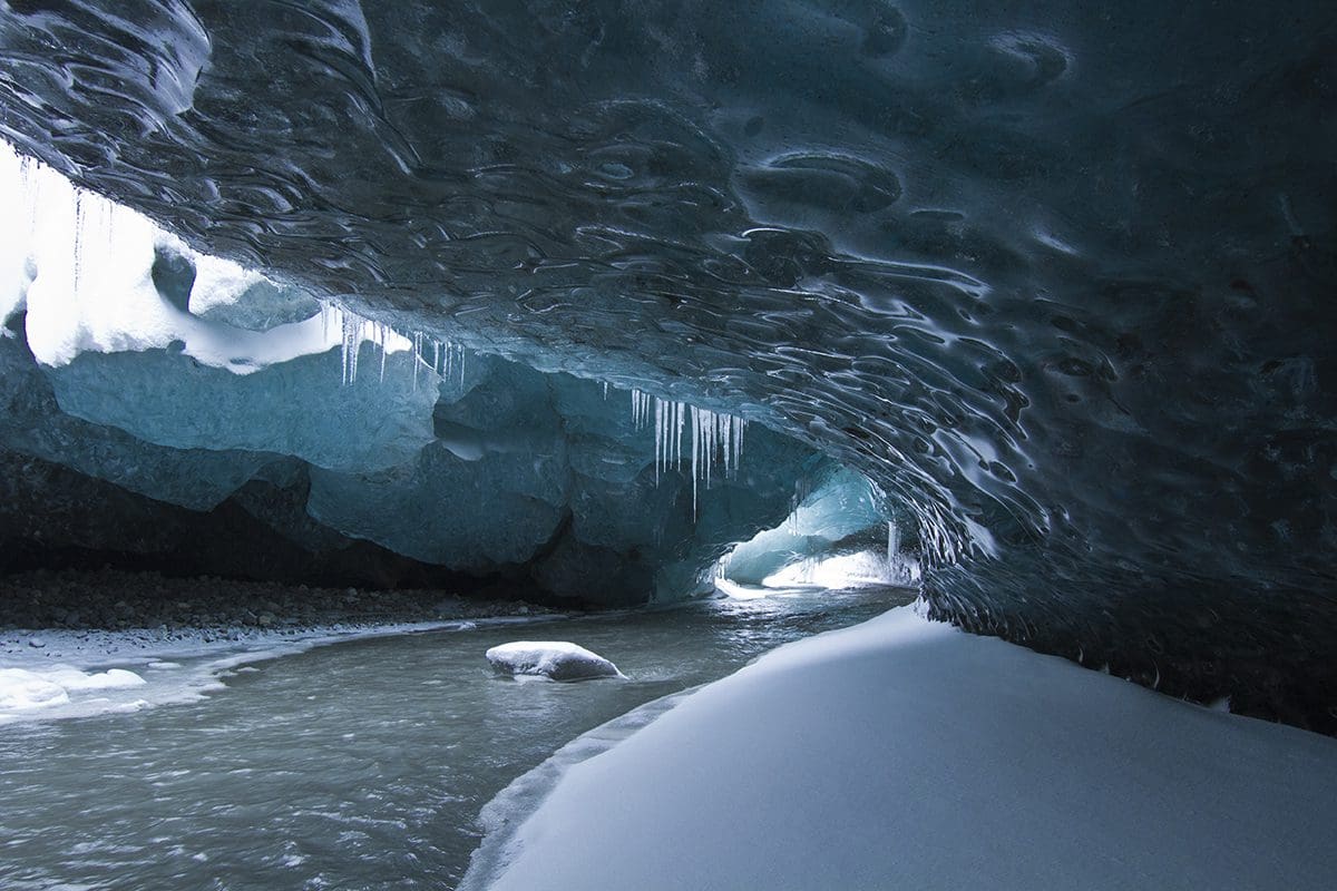 An ice cave with water flowing through it.