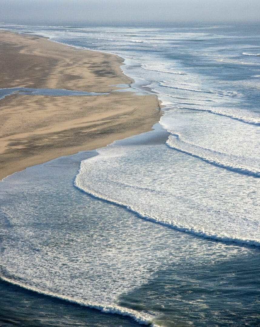 An aerial view of a beach with waves and sand.