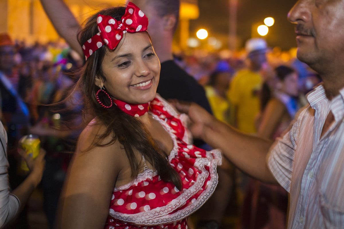 A woman in a polka dot dress dancing in a crowd.
