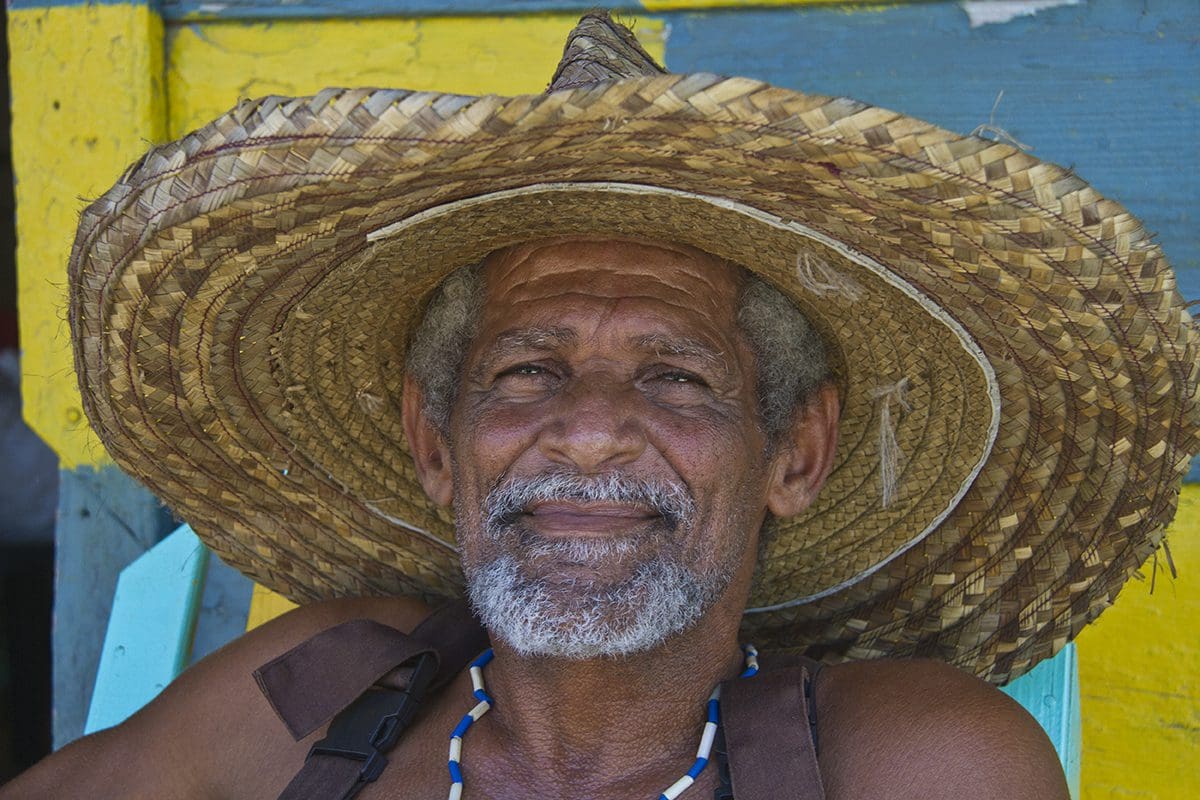 A man in a straw hat sitting in a chair.