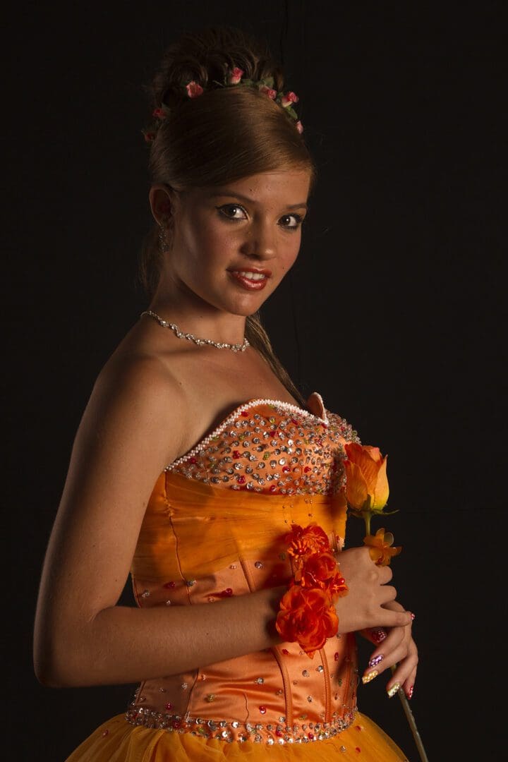 A girl in an orange dress posing for a photo.