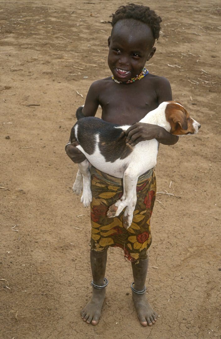 A young girl holding a dog.