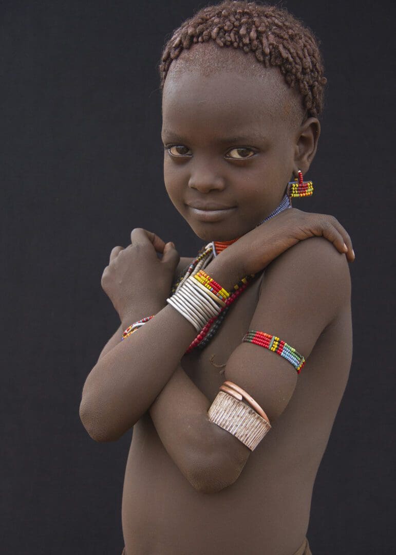 A young girl in a tribal outfit posing for a photo.