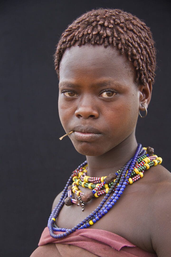 A young woman wearing a necklace and earrings.