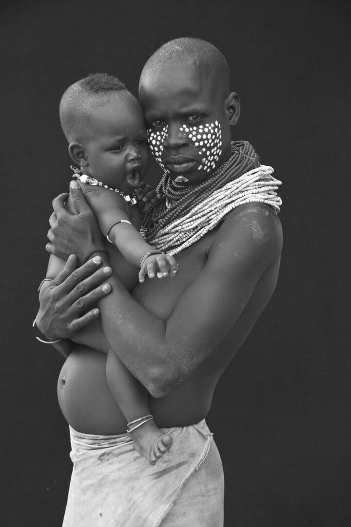 A black and white photo of a woman holding a child.