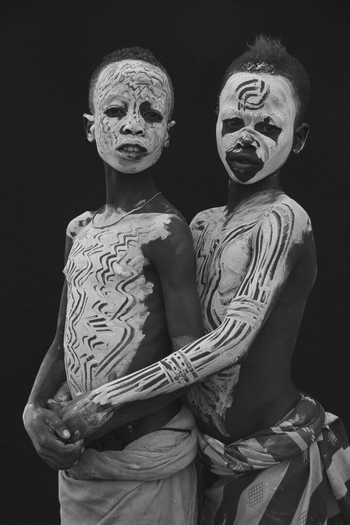 Two boys with painted faces posing for a photo.