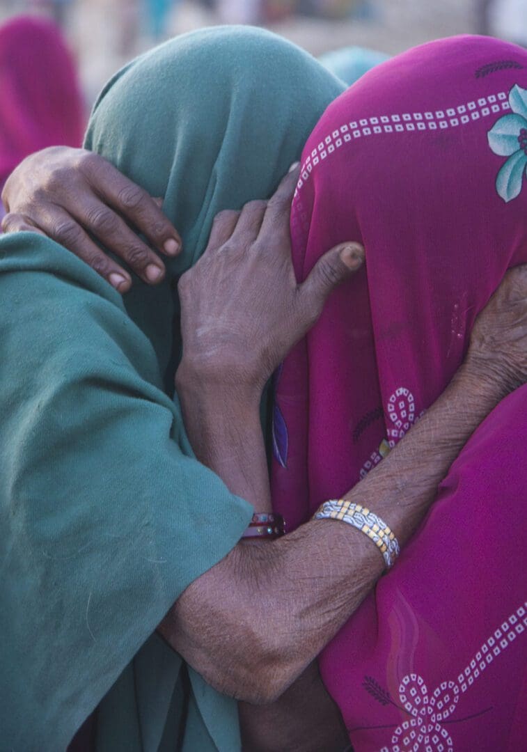 Two women hugging each other on a street in rajasthan.