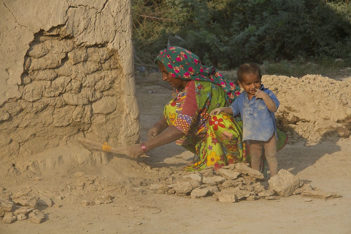 A woman and a child digging in the sand.