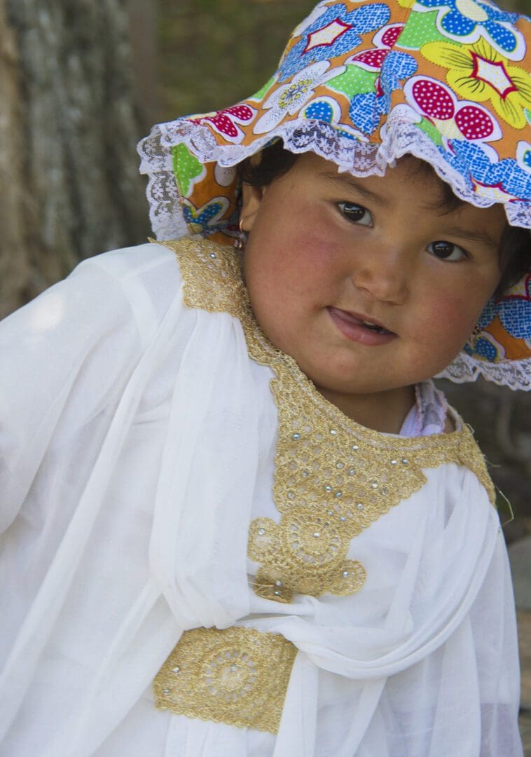 A young girl wearing a colorful hat.