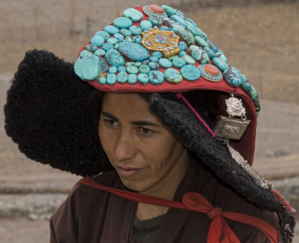 A woman wearing a hat with a lot of beads on it.