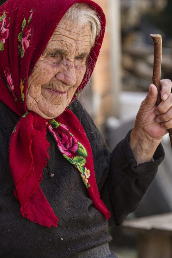 An old woman holding a stick.