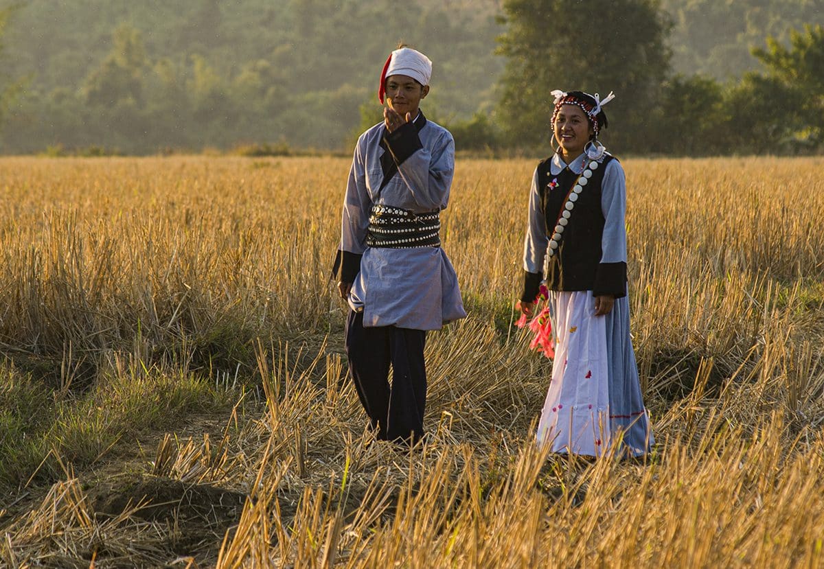 A man and a woman standing in a field.