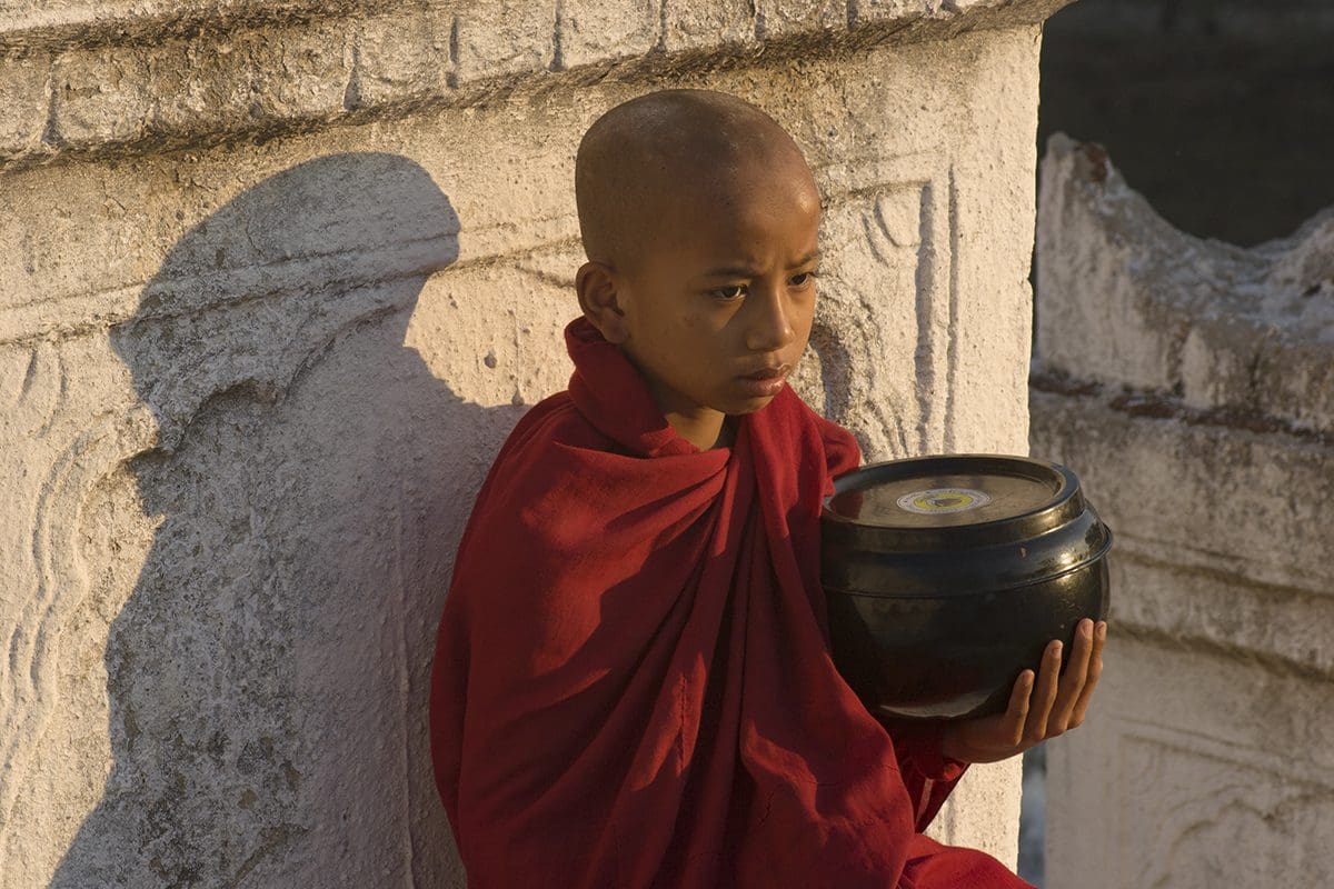 A young monk holding a bowl.
