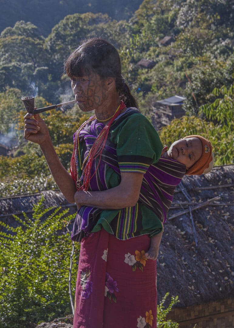 A woman carrying a child in a sling.