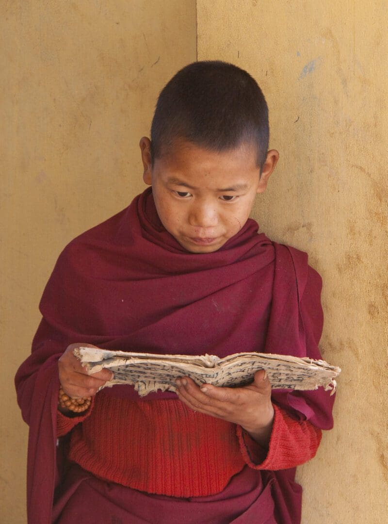 A young monk reading a newspaper.