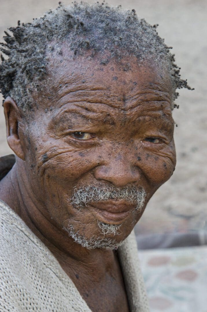 An old man with dreadlocks looking at the camera.