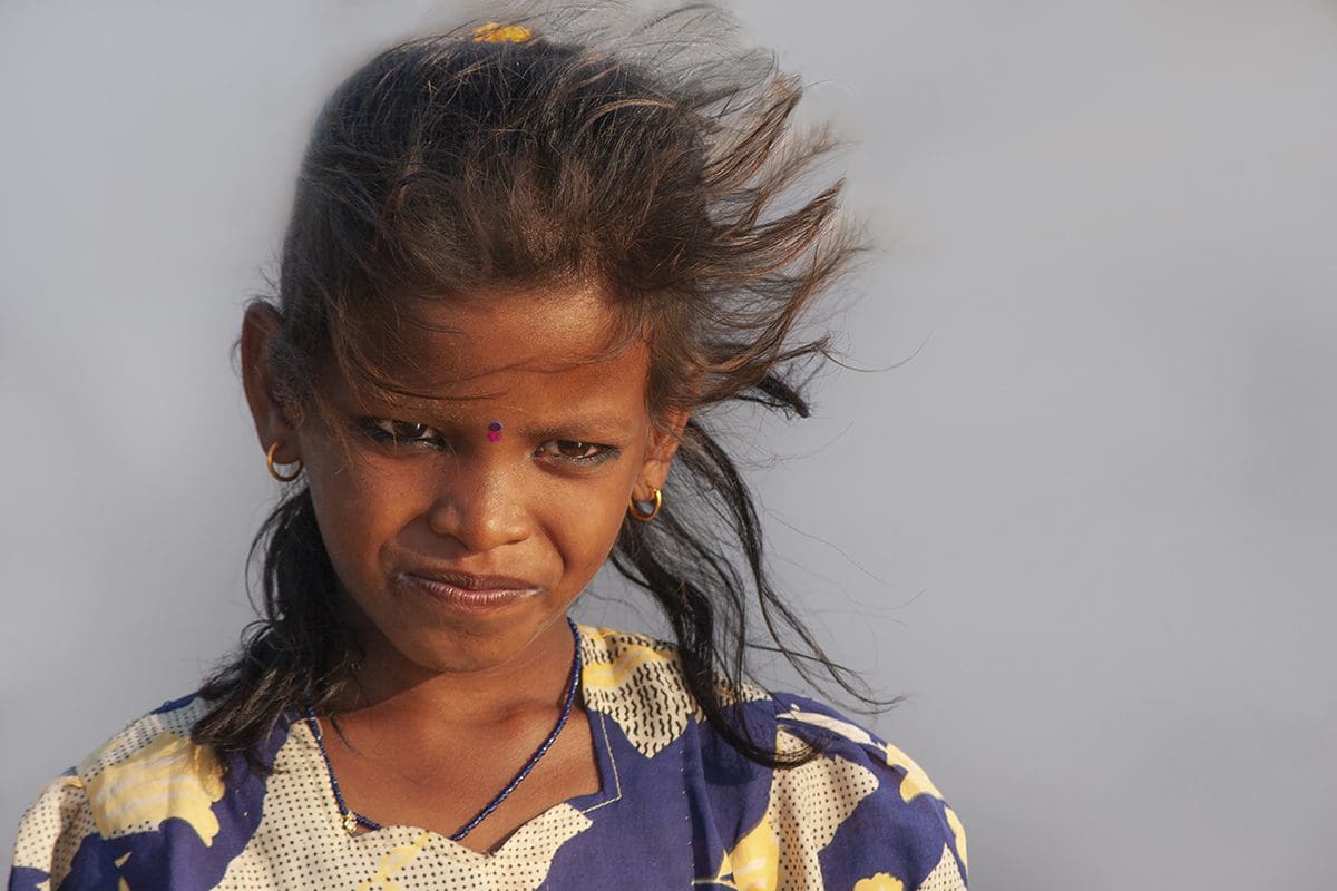 A young girl with her hair blowing in the wind.