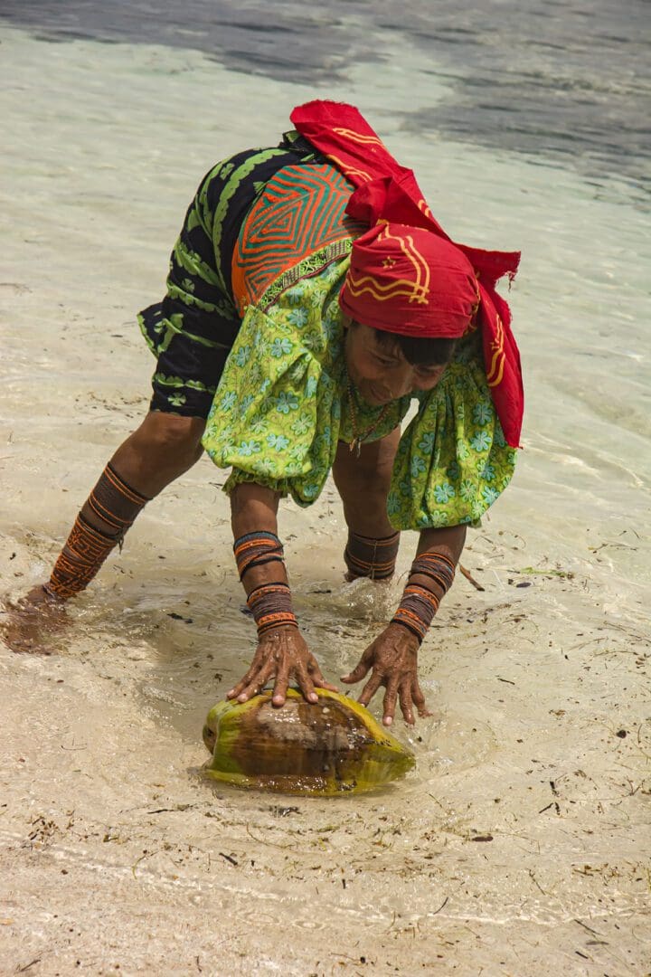 A woman is holding a coconut in the water.