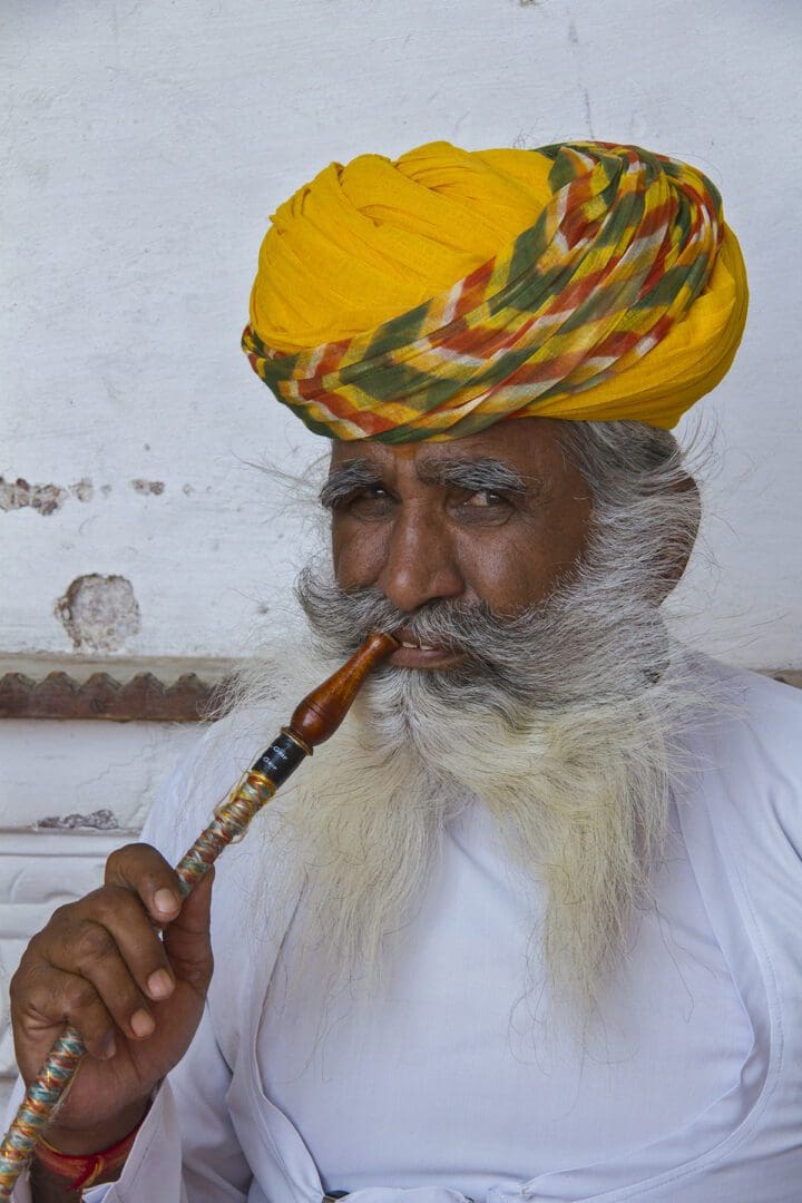 A man in a turban smoking a pipe.