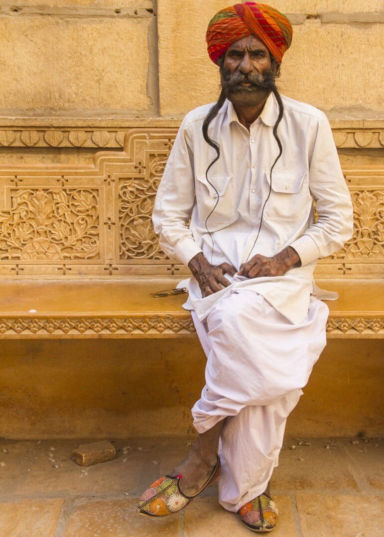 A man in a turban sitting on a bench.