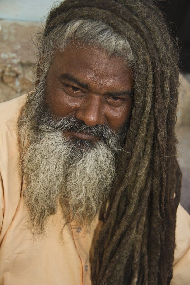 An indian man with dreadlocks and a beard.