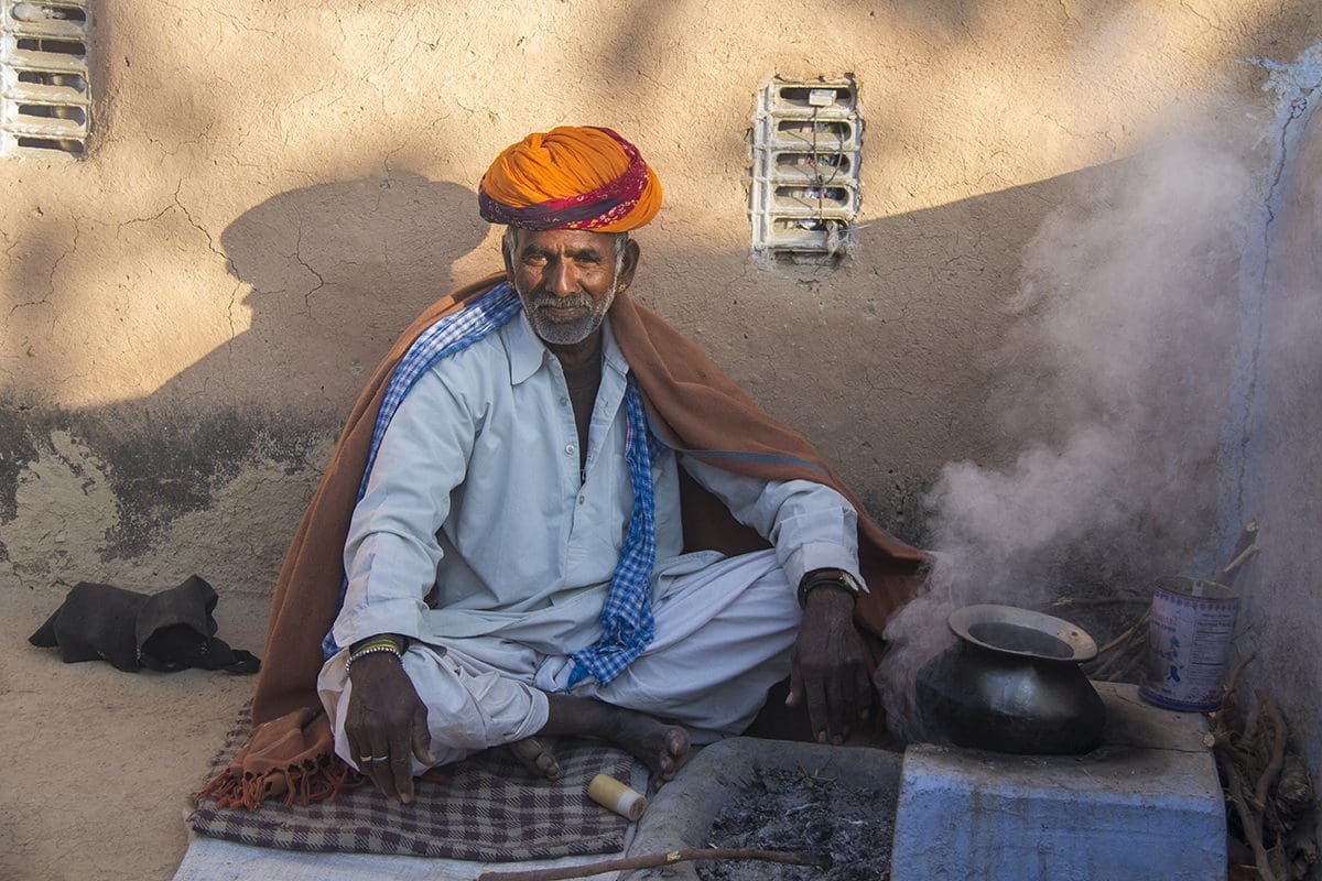 A man in a turban cooking a pot.