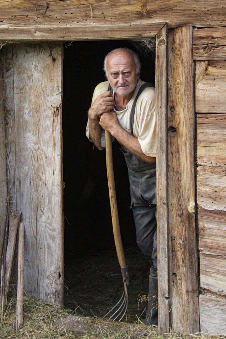 A man with a pitchfork standing in a doorway.