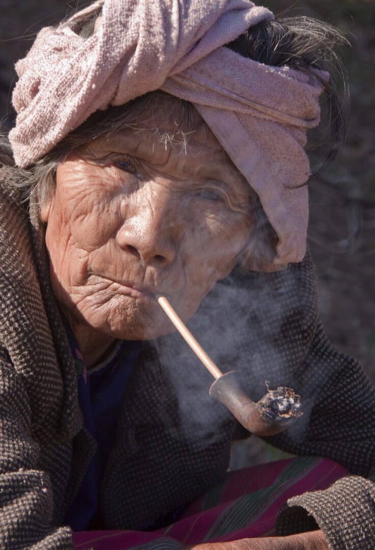 An old woman smoking a pipe.