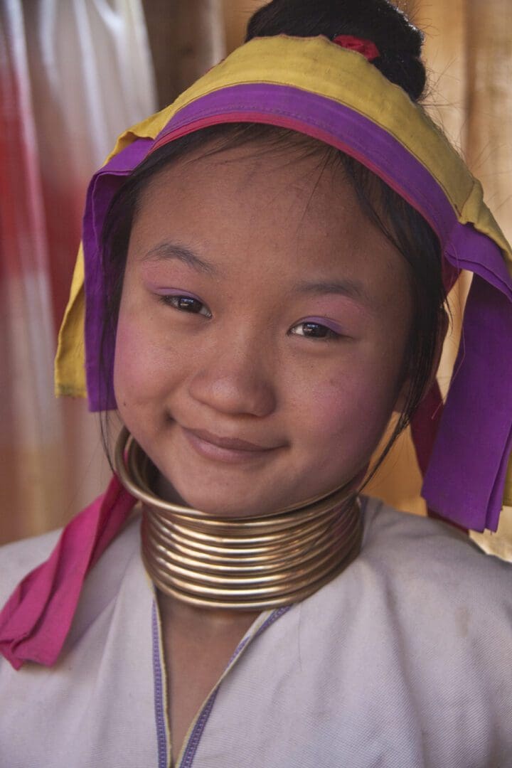 A young girl in a traditional dress with a necklace around her neck.