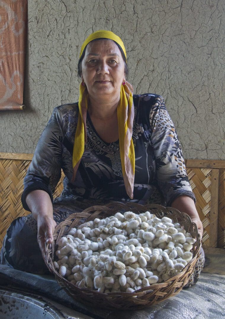 A woman holding a basket of white beans.