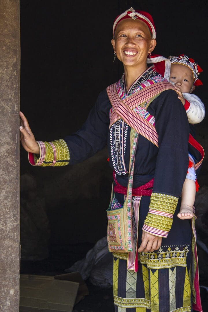 A woman in traditional clothing with a baby in her arms.