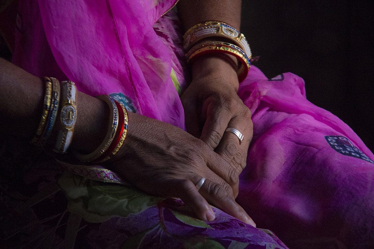 A woman's hands in a pink sari.