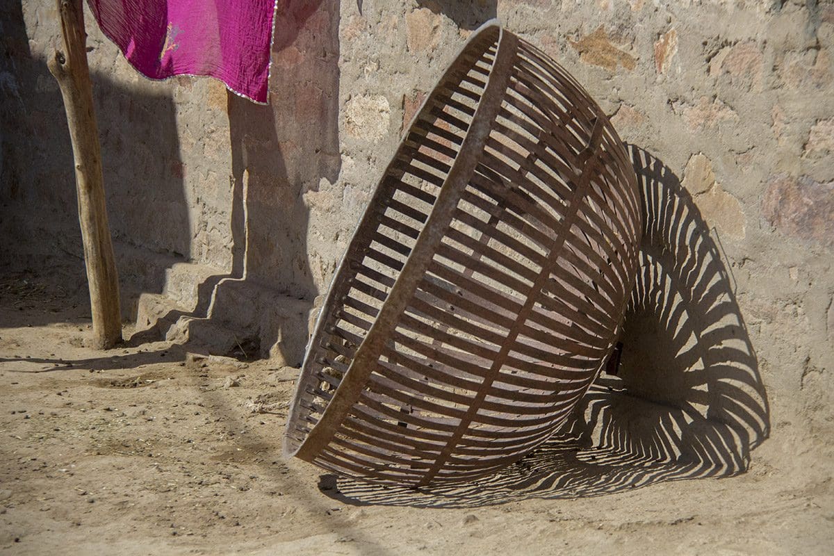 A basket sitting on the ground next to a wall.