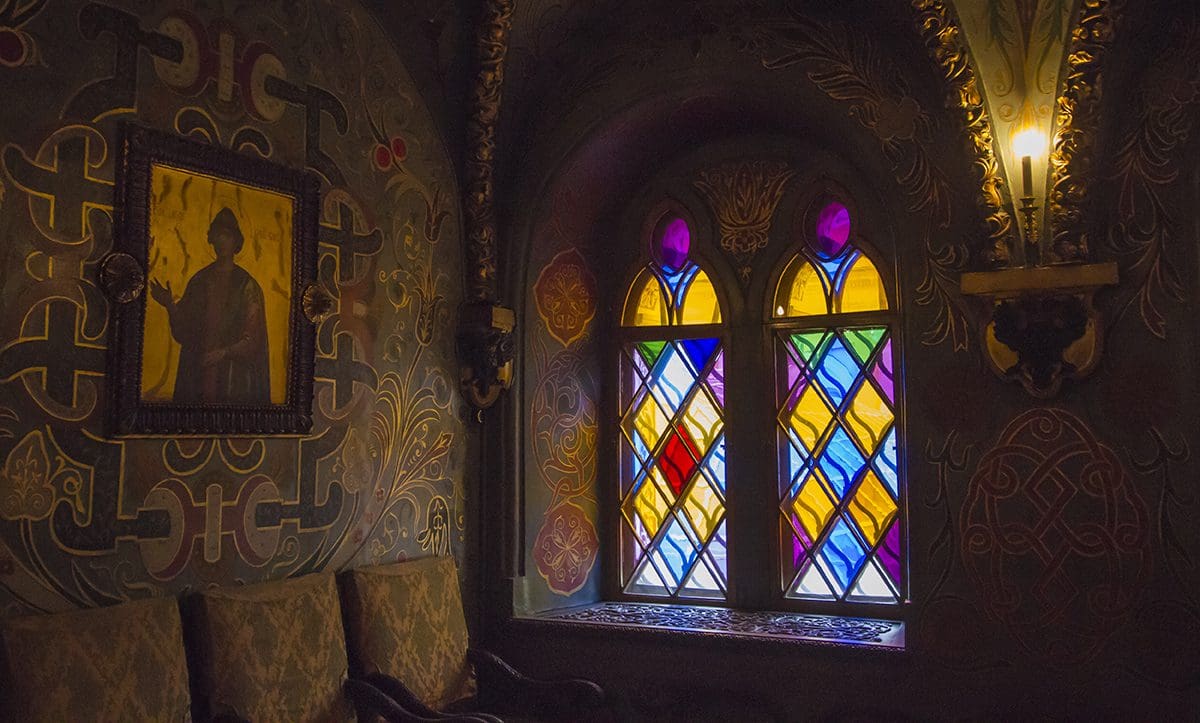 A stained glass window in an ornate room.