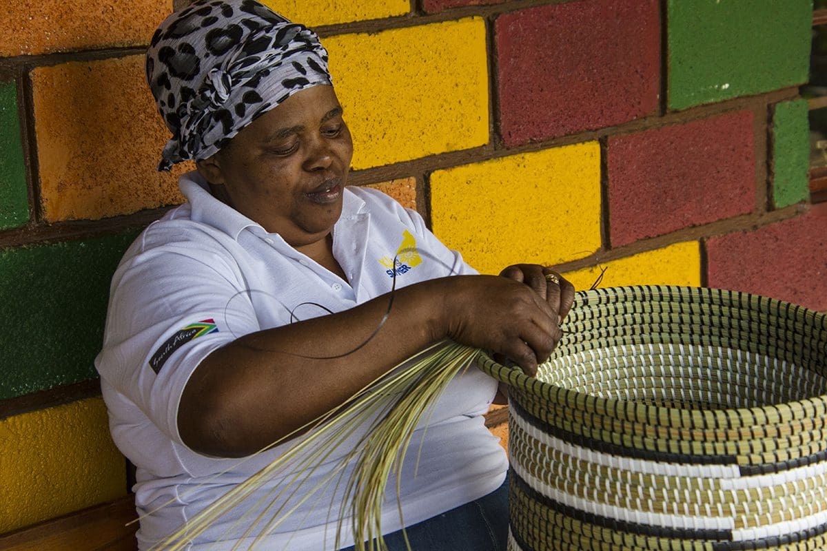 A woman is making a basket.