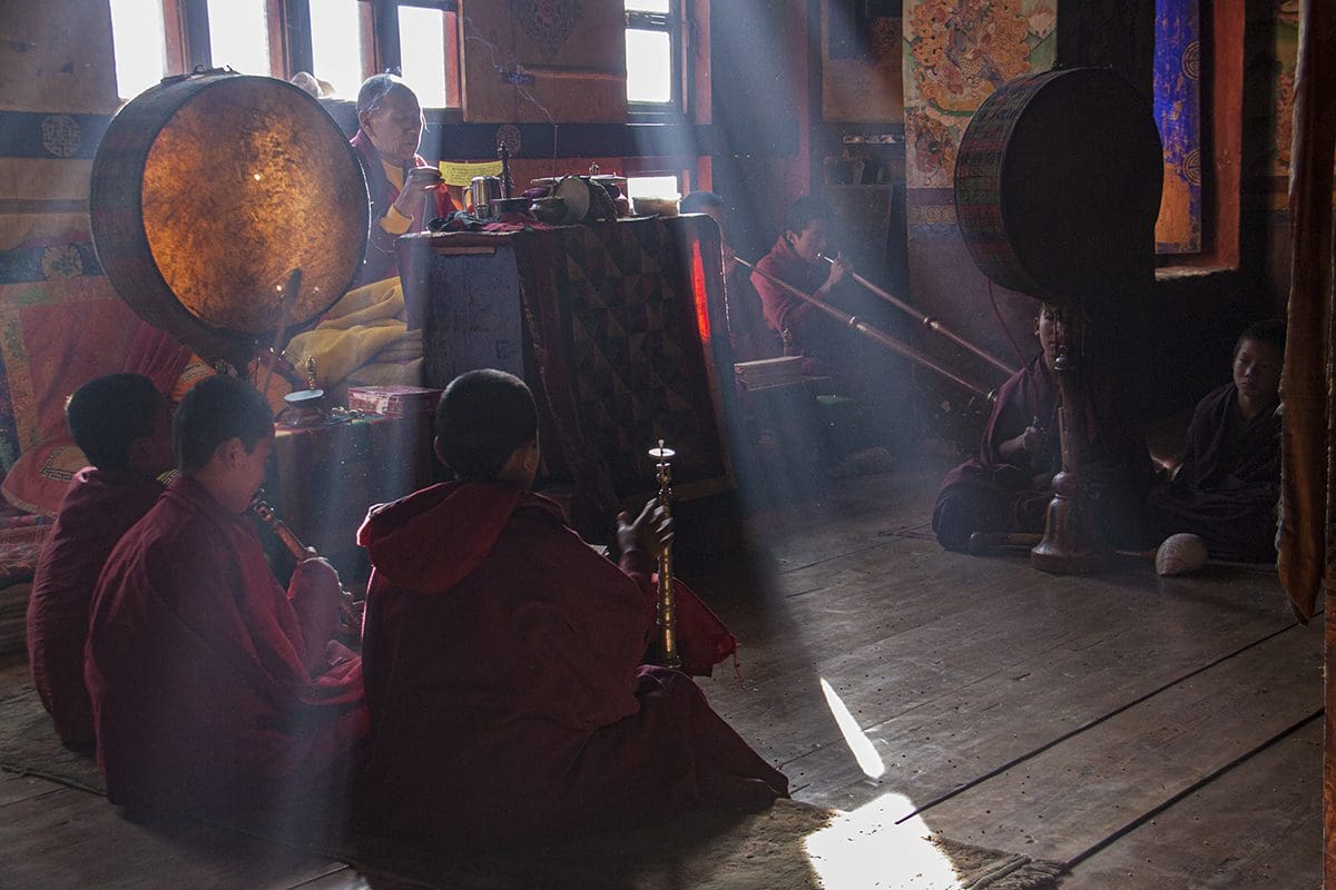 A group of monks playing instruments in a room.