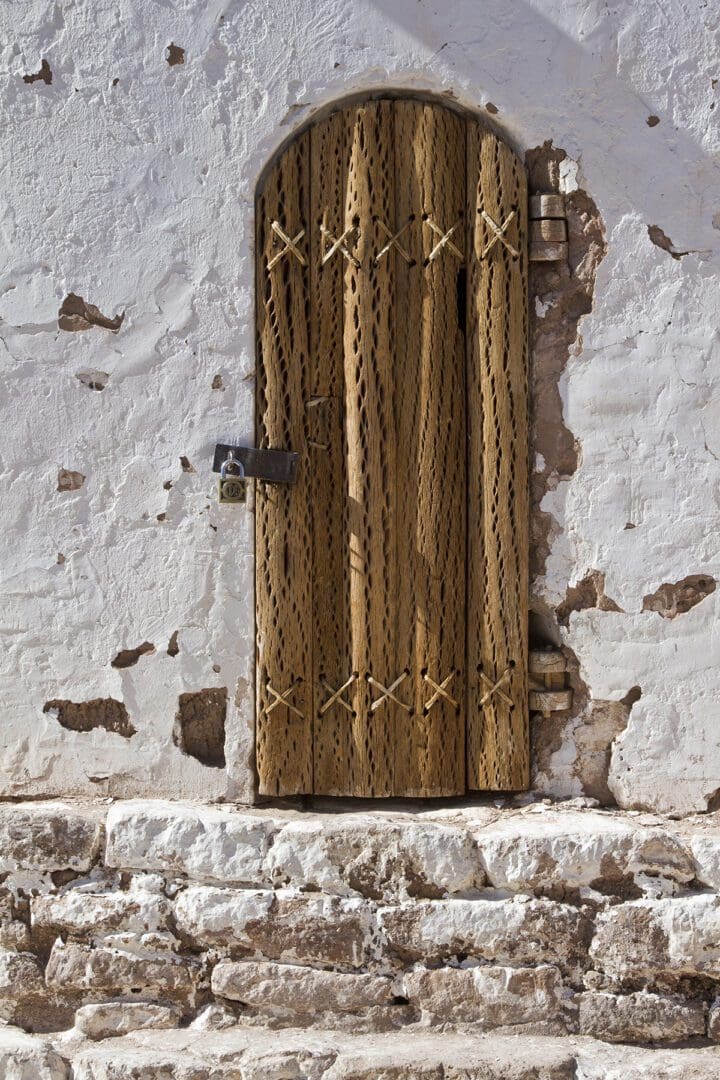 A wooden door on a white wall.
