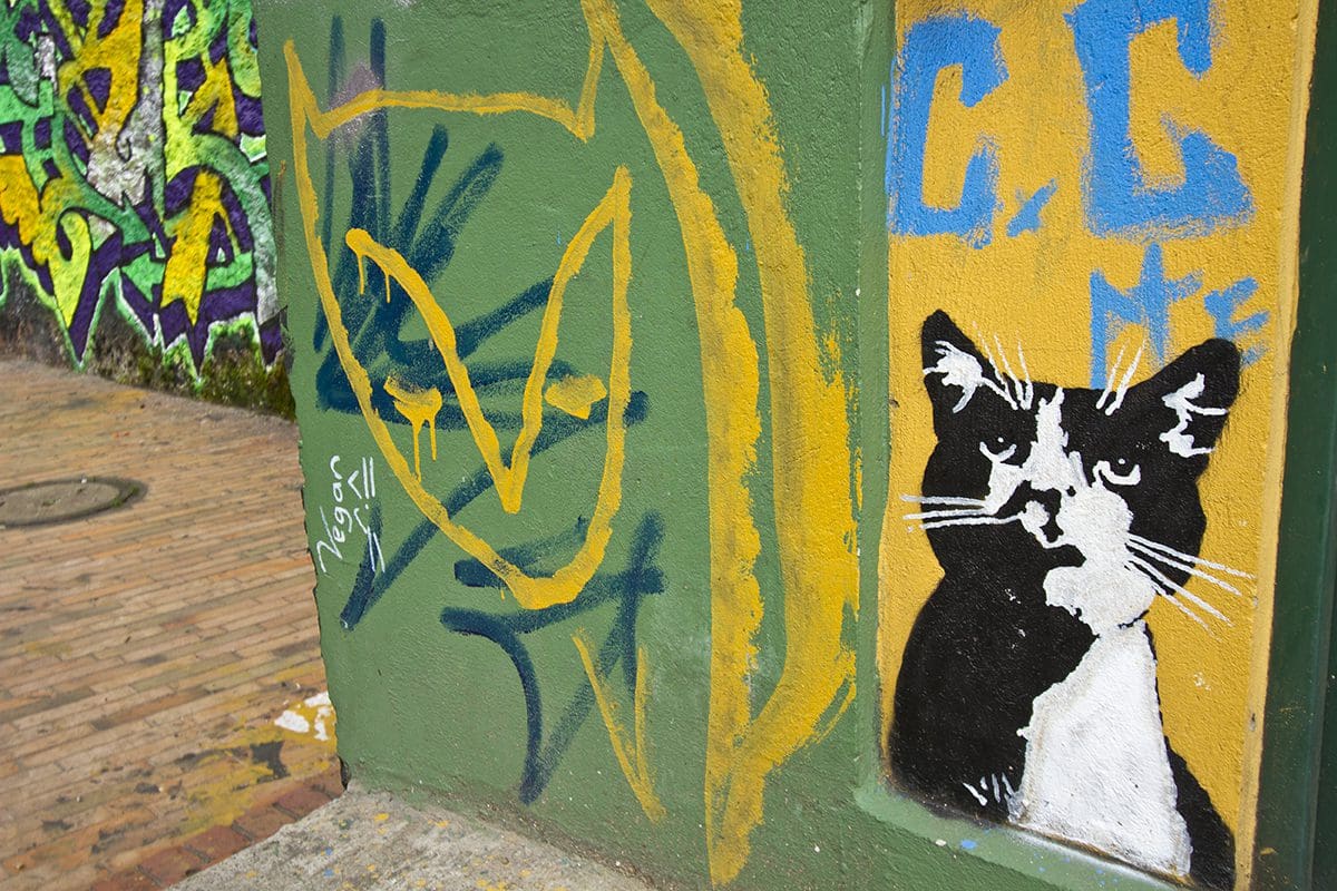A cat is painted on the side of a building.