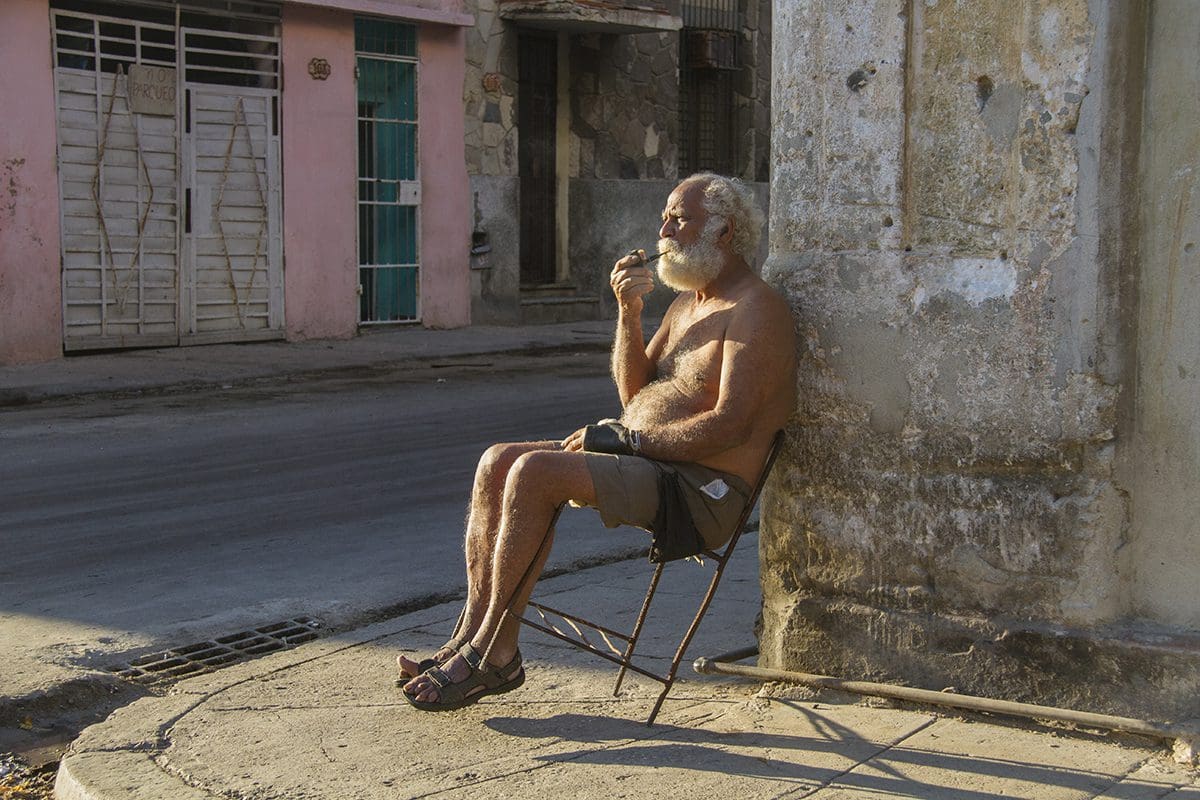 An old man sitting on a chair.