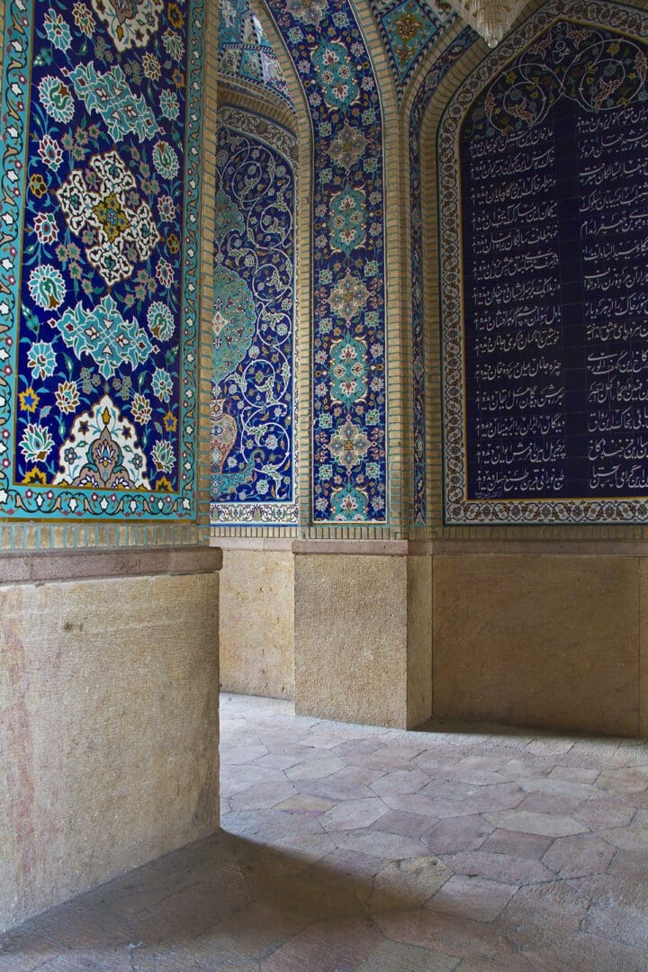 The interior of an ornate building with blue tiled walls.