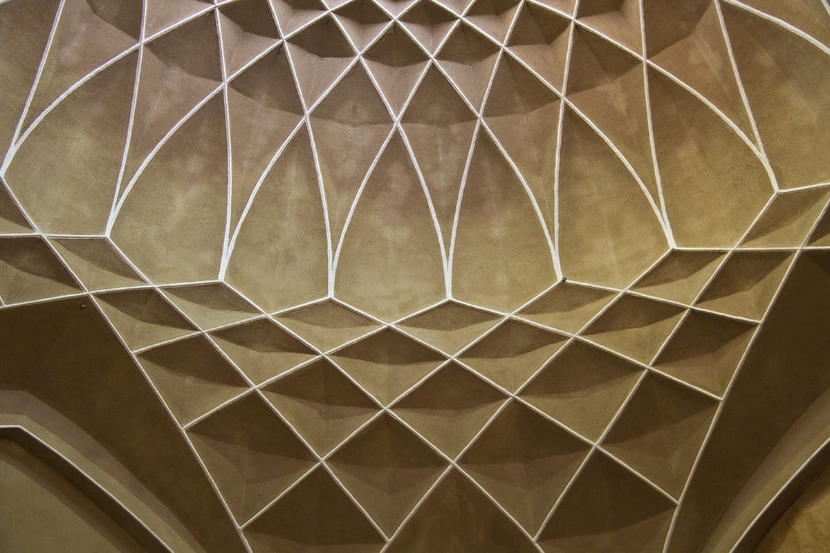The ceiling of a building is decorated with geometric patterns.