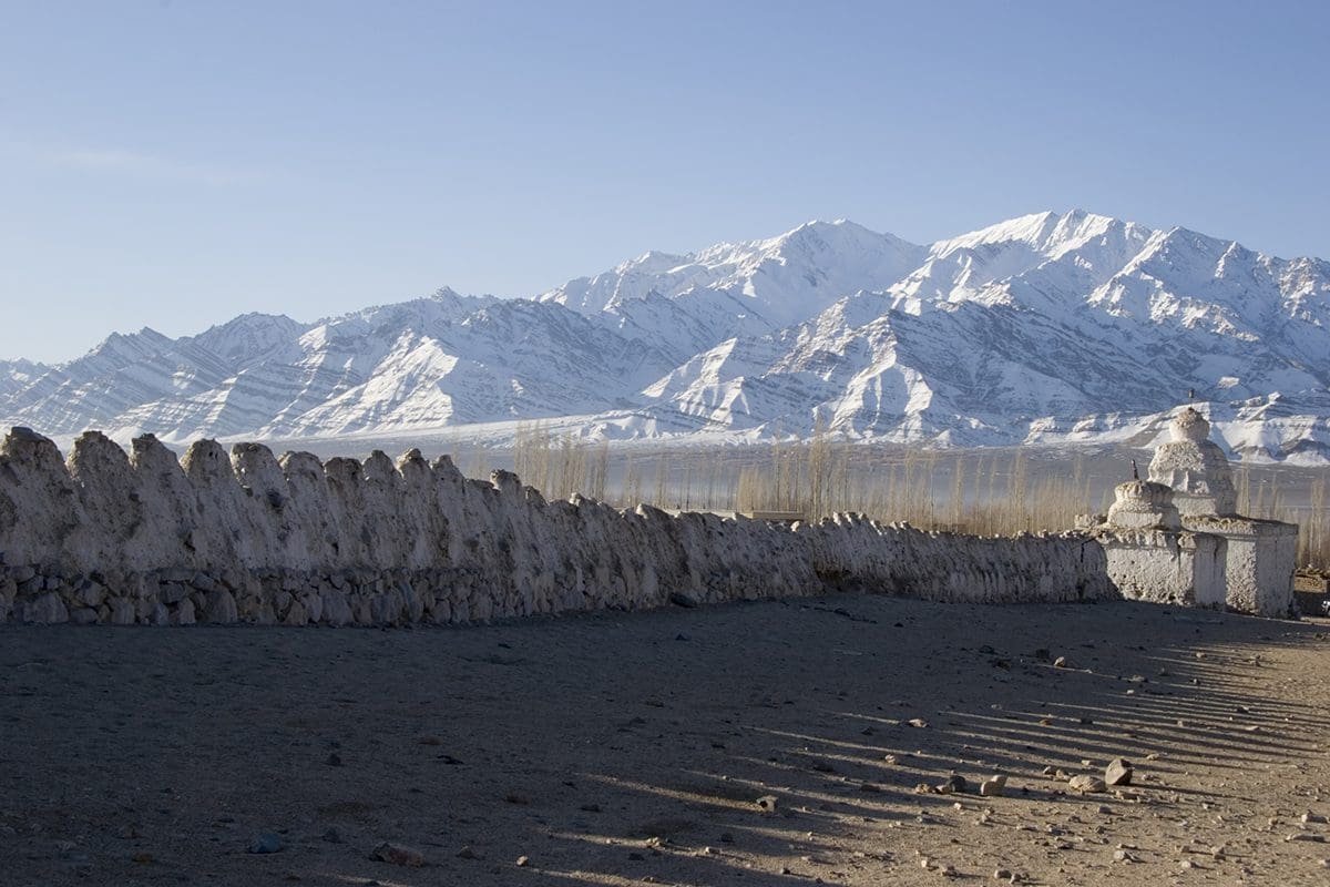 A stone wall with mountains in the background.