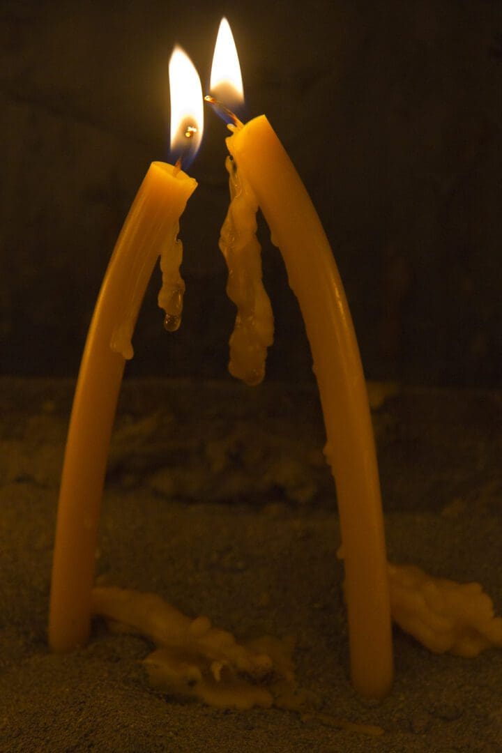 Two yellow candles are sitting on top of each other.