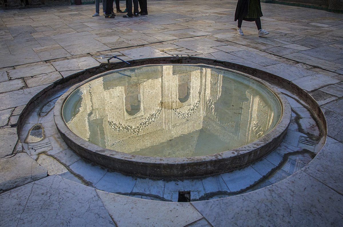 A circular fountain in the middle of a courtyard.