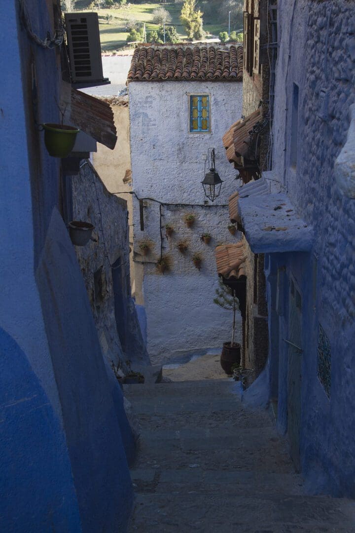 A narrow alleyway with blue painted buildings.