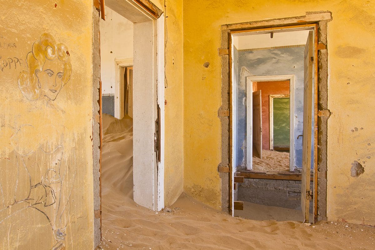 A room in an abandoned house with sand on the floor.