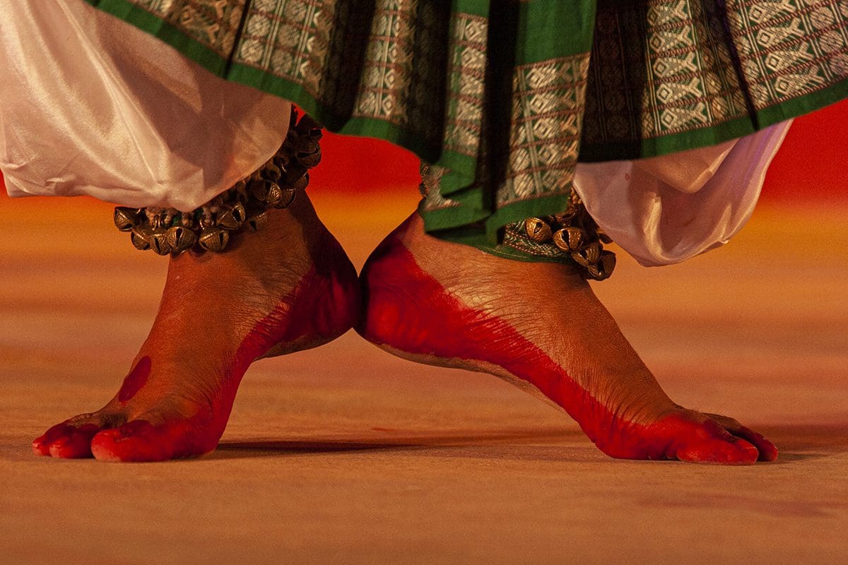 An indian dancer's feet with red paint on them.